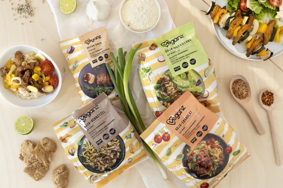 Auf einem Tisch liegen verschiedene Produkte in Ihrer Verpackung von Veganz. Alle Produkte sind auf Soja Basis.