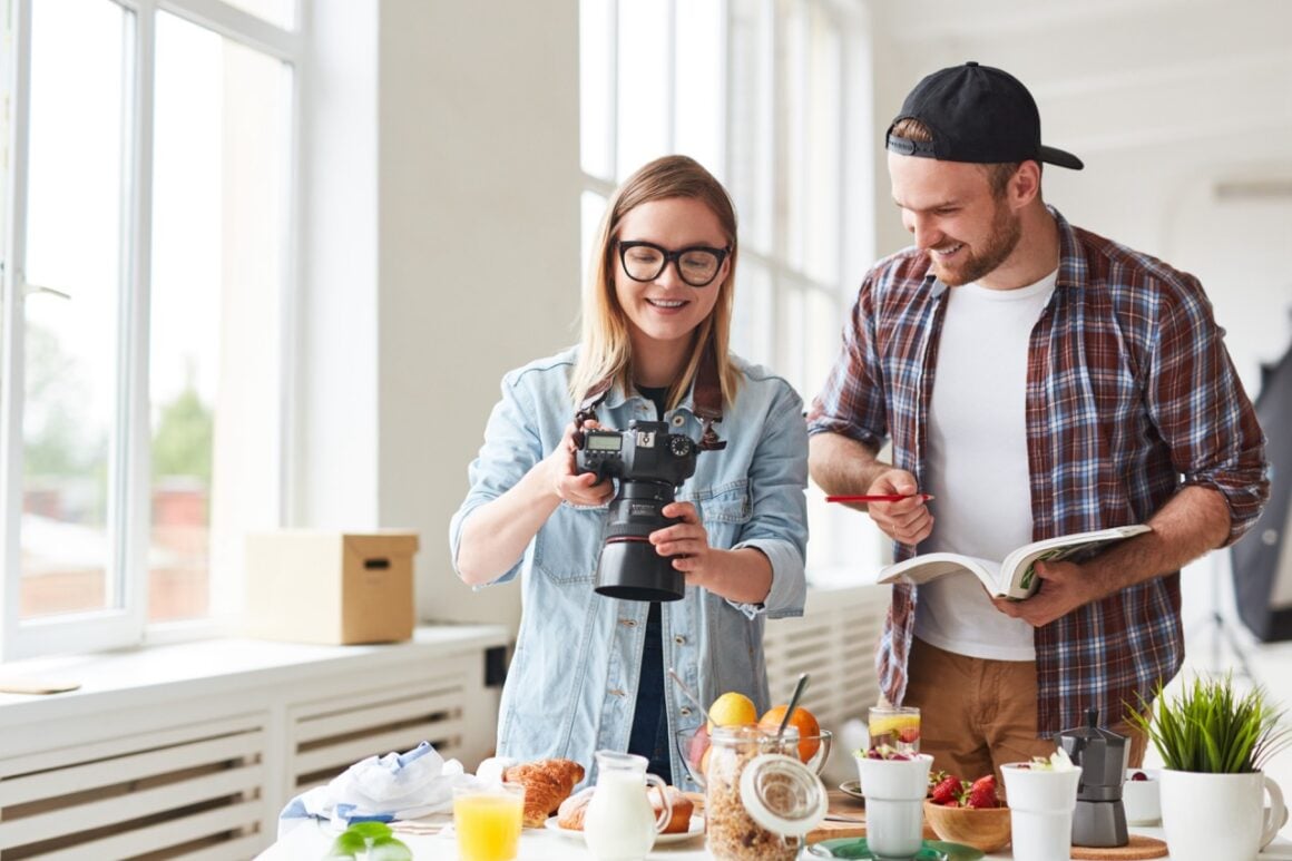 Junger Mann und Frau stehen vor verschiedenen veganen Zutaten für ein Food Fotografie Shooting in einem Fotostudio