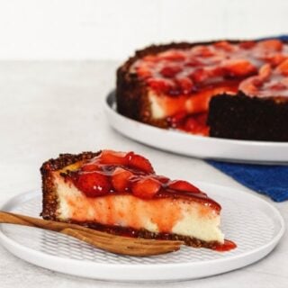Veganer Cheesecake mit Erdbeeren, an dem Erbeersoße runterläuft