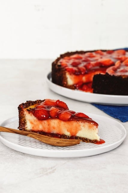 Veganer Cheesecake mit Erdbeeren, an dem Erbeersoße runterläuft