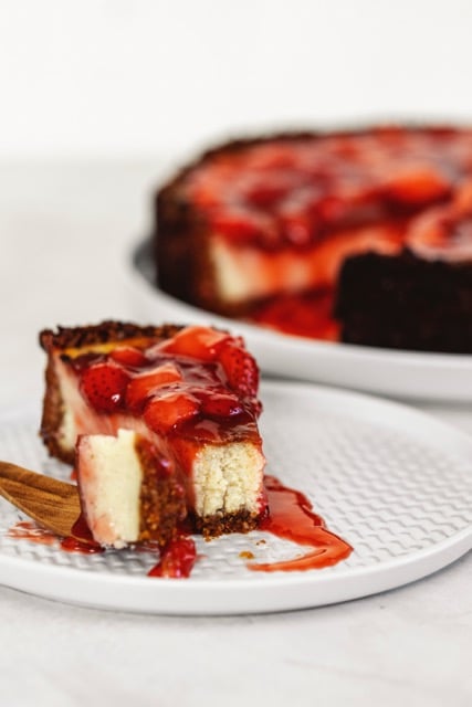 Veganer Cheesecake mit Erdbeeren, an dem Erbeersoße runterläuft
